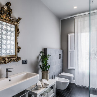 Idee per una stanza da bagno mediterranea con pareti grigie, parquet scuro, lavabo sospeso e pavimento nero