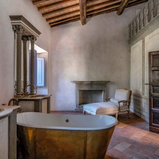 Ispirazione per una stanza da bagno mediterranea con vasca freestanding, pareti grigie, lavabo da incasso, pavimento rosso, top bianco, due lavabi, mobile bagno incassato, travi a vista, soffitto a volta e soffitto in legno