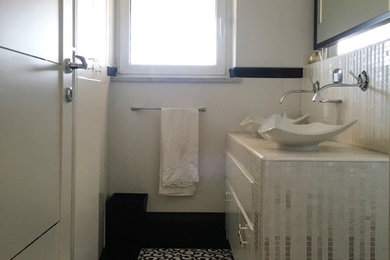 ローマにある高級な中くらいなコンテンポラリースタイルのおしゃれなマスターバスルーム (フラットパネル扉のキャビネット、白いキャビネット、分離型トイレ、モノトーンのタイル、磁器タイル、白い壁、磁器タイルの床、ベッセル式洗面器、タイルの洗面台、マルチカラーの床) の写真