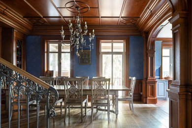 Réalisation d'une salle à manger victorienne avec un mur bleu et un sol beige.