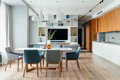 Стильный дизайн: гостиная-столовая в современном стиле с серыми стенами, светлым паркетным полом и бежевым полом без камина - последний тренд