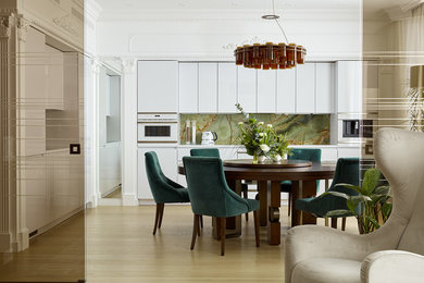 Inspiration pour une salle à manger ouverte sur la cuisine design avec parquet clair, un sol beige et un mur blanc.