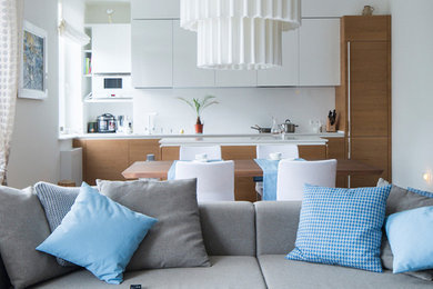 Inspiration pour une salle à manger ouverte sur le salon design avec un mur blanc et un sol en bois brun.