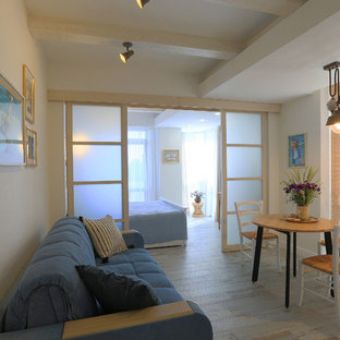 Idées déco pour une petit salle à manger ouverte sur le salon bord de mer avec un mur blanc, un sol en carrelage de porcelaine et un sol turquoise.