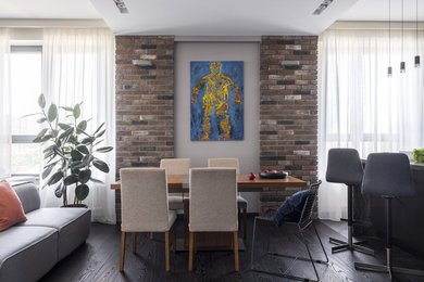 Immagine di una sala da pranzo aperta verso il soggiorno design di medie dimensioni con pareti beige, parquet scuro e pavimento nero
