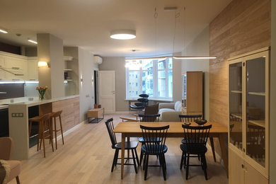 Свежая идея для дизайна: кухня-столовая в скандинавском стиле с серыми стенами, светлым паркетным полом, коричневым полом и деревянными стенами без камина - отличное фото интерьера