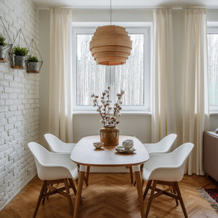 Ispirazione per una sala da pranzo nordica con pareti bianche, pavimento in legno massello medio, pavimento marrone e pareti in mattoni