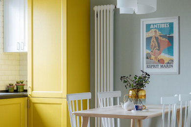На фото: кухня-столовая в стиле неоклассика (современная классика) с зелеными стенами, светлым паркетным полом и бежевым полом