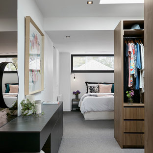 Modernes Ankleidezimmer mit Ankleidebereich, offenen Schränken, hellbraunen Holzschränken, Teppichboden und grauem Boden in Melbourne