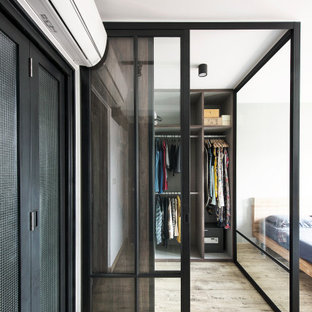 Ispirazione per una cabina armadio unisex industriale con nessun'anta, ante grigie, parquet chiaro e pavimento beige