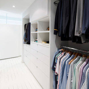 Esempio di una piccola cabina armadio unisex contemporanea con pavimento in legno verniciato e ante bianche