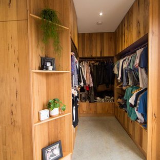 Ispirazione per una grande cabina armadio design con ante in legno scuro, pavimento in cemento e pavimento grigio