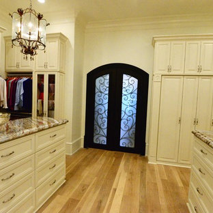 Idee per un ampio spazio per vestirsi unisex chic con ante con riquadro incassato, ante beige, parquet chiaro e pavimento beige