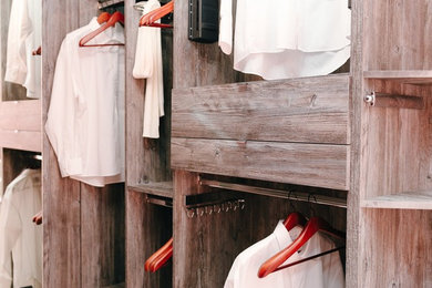 Ejemplo de armario vestidor unisex minimalista de tamaño medio con armarios abiertos, puertas de armario de madera oscura y suelo de baldosas de terracota