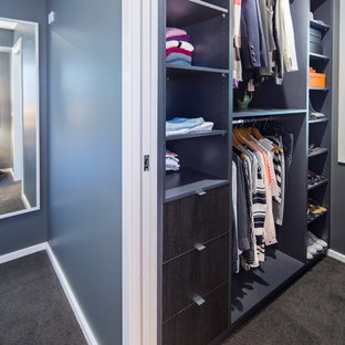 Foto di una piccola cabina armadio unisex design con nessun'anta, ante in legno bruno e moquette