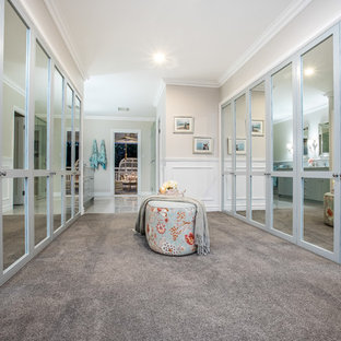 Photo of a large traditional gender-neutral dressing room in Brisbane with shaker cabinets, blue cabinets, carpet and grey floor.