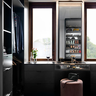 Inspiration for a victorian gender-neutral dressing room in Melbourne with flat-panel cabinets, black cabinets, carpet and blue floor.