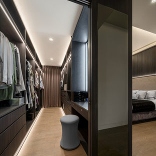 Esempio di un grande spazio per vestirsi unisex design con ante lisce, ante in legno bruno e pavimento beige