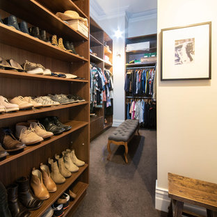 Expansive transitional gender-neutral walk-in wardrobe in Melbourne with open cabinets, medium wood cabinets, carpet and grey floor.