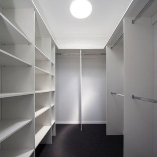 Immagine di una cabina armadio unisex minimal di medie dimensioni con nessun'anta, ante bianche, moquette e pavimento nero
