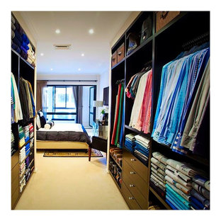 Diseño de armario vestidor de hombre, moderno, grande, con armarios abiertos, puertas de armario negras y moqueta