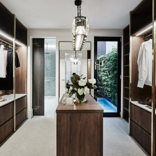 Contemporary gender-neutral dressing room in Melbourne with dark wood cabinets and grey floor.