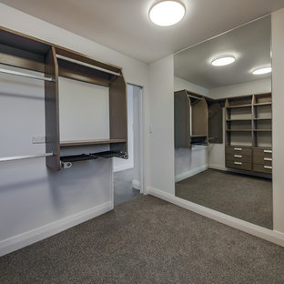 Immagine di una cabina armadio unisex stile marinaro di medie dimensioni con nessun'anta, ante in legno bruno, moquette e pavimento grigio