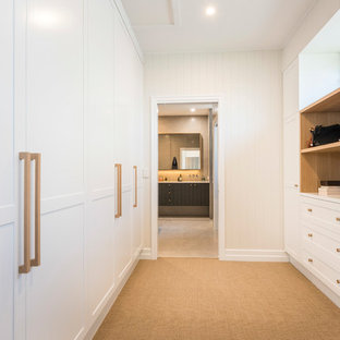 This is an example of a transitional gender-neutral walk-in wardrobe in Brisbane with shaker cabinets, white cabinets, carpet and beige floor.
