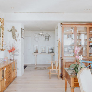 Immagine di uno studio tradizionale con parquet chiaro, libreria, pareti bianche, scrivania autoportante e pavimento beige