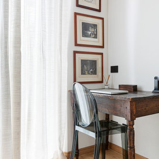 Inredning av ett minimalistiskt litet arbetsrum, med vita väggar, ljust trägolv, ett fristående skrivbord och beiget golv