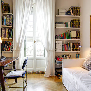 Esempio di uno studio chic di medie dimensioni con libreria, parquet chiaro, scrivania autoportante, pareti beige, nessun camino e pavimento beige
