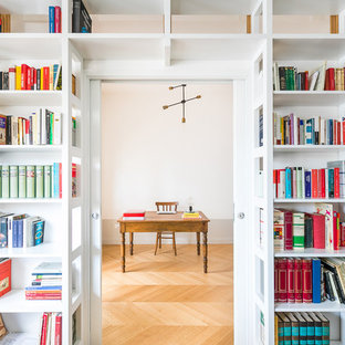 Esempio di uno studio classico con libreria, parquet chiaro, scrivania autoportante, pareti bianche e pavimento beige