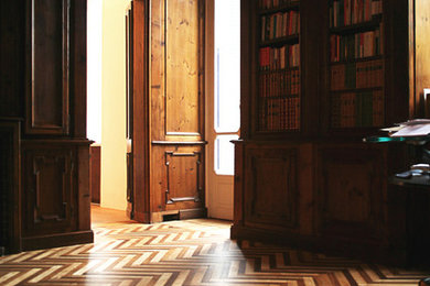 Modelo de despacho tradicional de tamaño medio con biblioteca, paredes marrones, suelo de madera oscura y suelo marrón