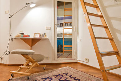 Foto de despacho actual con paredes blancas y suelo de madera en tonos medios