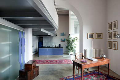 ミラノにある広いエクレクティックスタイルのおしゃれなホームオフィス・書斎 (白い壁、コンクリートの床) の写真