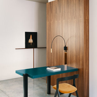 Immagine di un piccolo ufficio design con pareti bianche, scrivania incassata, pavimento grigio e pareti in legno