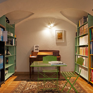 Idee per un grande studio bohémian con libreria, pareti bianche, pavimento marrone, parquet chiaro e scrivania incassata