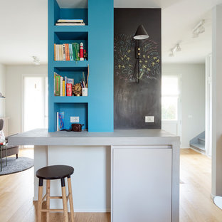 Foto di uno studio bohémian con pareti blu, pavimento in legno massello medio, scrivania incassata e pavimento marrone