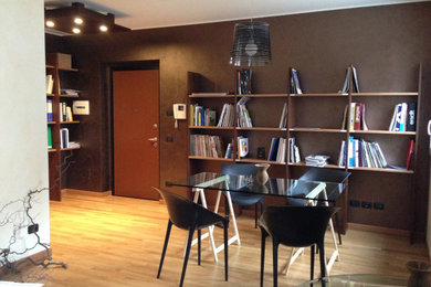 ミラノにあるお手頃価格の小さなコンテンポラリースタイルのおしゃれな書斎 (茶色い壁、淡色無垢フローリング、自立型机、ベージュの床) の写真