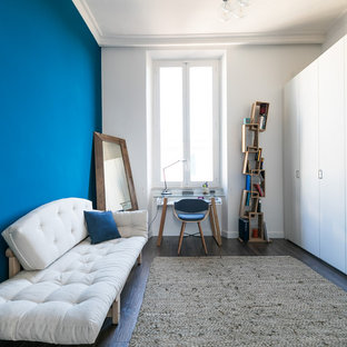 Ispirazione per un ufficio minimal con pareti blu, scrivania autoportante, parquet scuro e nessun camino