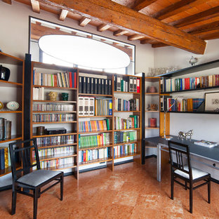 Idee per uno studio mediterraneo con libreria, pareti bianche, scrivania autoportante e pavimento marrone