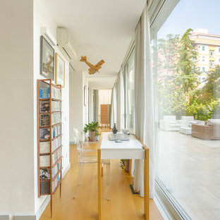 Foto di un grande studio minimal con pareti bianche, pavimento in legno massello medio, scrivania autoportante e pavimento marrone