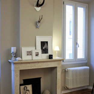Modern inredning av ett hobbyrum, med beige väggar, ljust trägolv, en standard öppen spis och en spiselkrans i sten