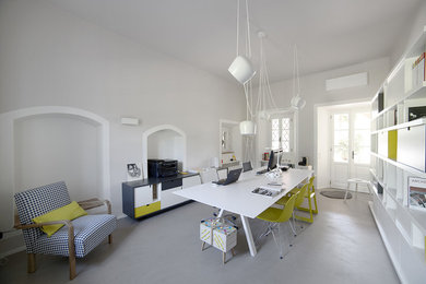 Idee per un atelier design di medie dimensioni con pareti grigie e pavimento in cemento