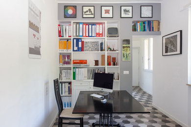 Idee per un ufficio design di medie dimensioni con pareti grigie, pavimento in gres porcellanato, scrivania autoportante e pavimento grigio