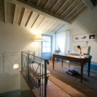 Cette image montre un petit bureau rustique de type studio avec un sol en brique.