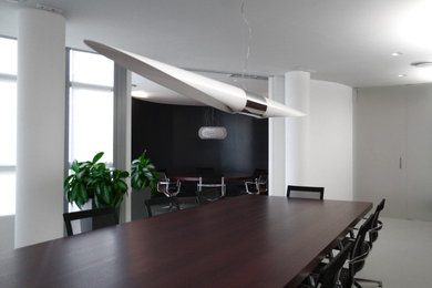 Modelo de despacho moderno grande con paredes blancas, suelo de cemento y suelo gris