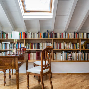 Foto di uno studio classico con libreria, pareti bianche, scrivania autoportante, pavimento marrone e parquet chiaro