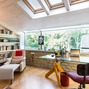 Idee per uno studio mediterraneo con libreria, pavimento in legno massello medio, nessun camino e scrivania autoportante