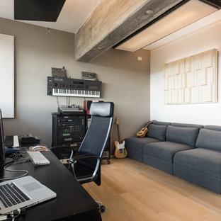 Immagine di un atelier minimal con pareti grigie, parquet chiaro, scrivania autoportante e pavimento beige